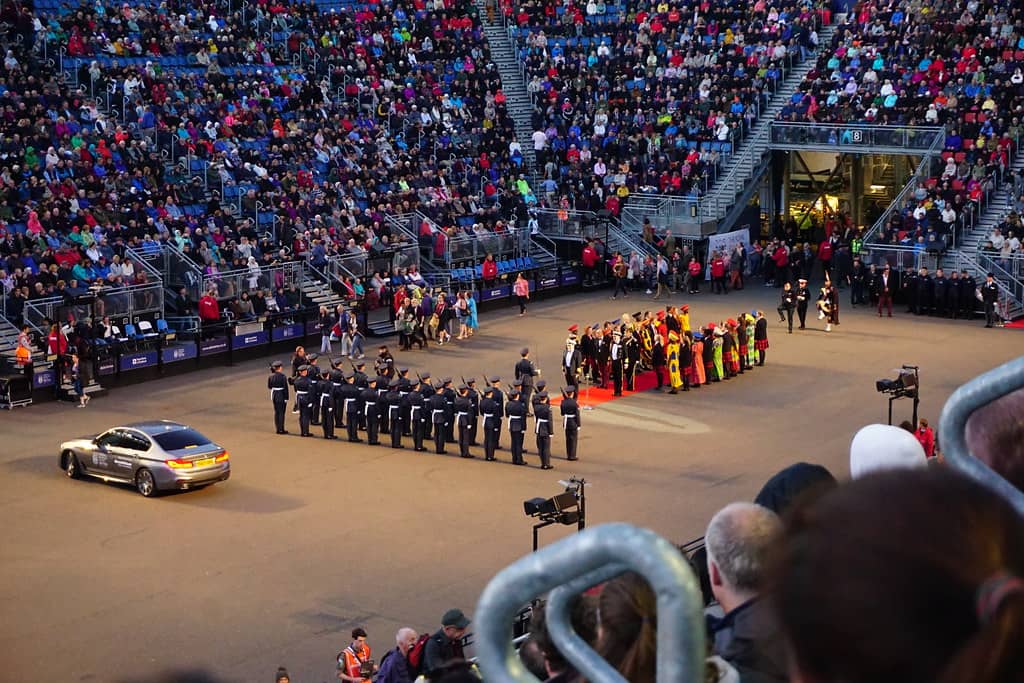 The Royal Edinburgh Military Tattoo in Scotland, featuring a military band formation with participants in traditional uniforms and a large audience watching from the stands. This image exemplifies what a military tattoo in Scotland is, blending military precision with cultural heritage in a grand ceremonial event.