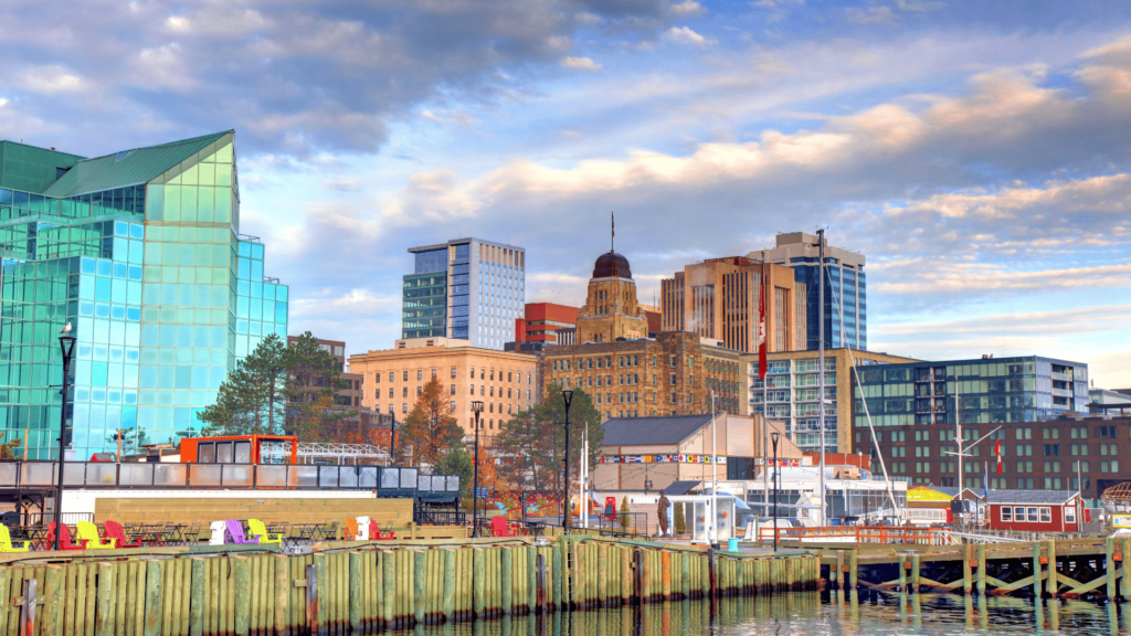 Scenic view of downtown Halifax, showcasing modern glass buildings, historic architecture, and the vibrant waterfront area. Perfect for visitors attending the Royal Nova Scotia Military Tattoo, with comfortable seating areas and a scenic harbor setting.