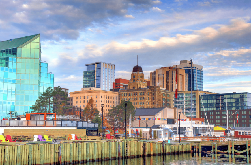 Scenic view of downtown Halifax, showcasing modern glass buildings, historic architecture, and the vibrant waterfront area. Perfect for visitors attending the Royal Nova Scotia Military Tattoo, with comfortable seating areas and a scenic harbor setting.