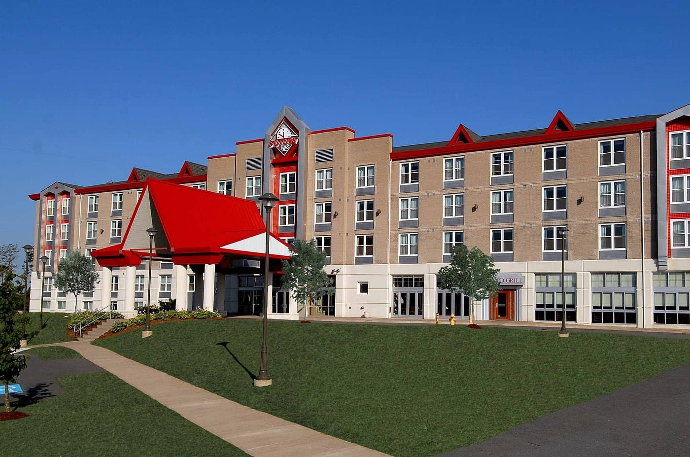 Exterior view of Future Inns Halifax Hotel  Conference Centre showcasing a modern multi-story building with beige walls red accents and a welcoming main entrance with a red roof