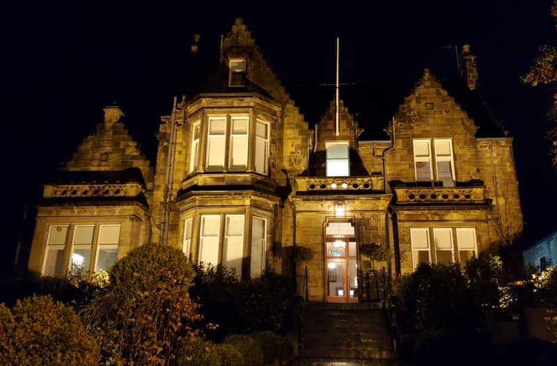 The Dunstane Houses in Edinburgh a beautifully lit historic mansion offering luxurious boutique accommodations showcasing its elegant architecture at night