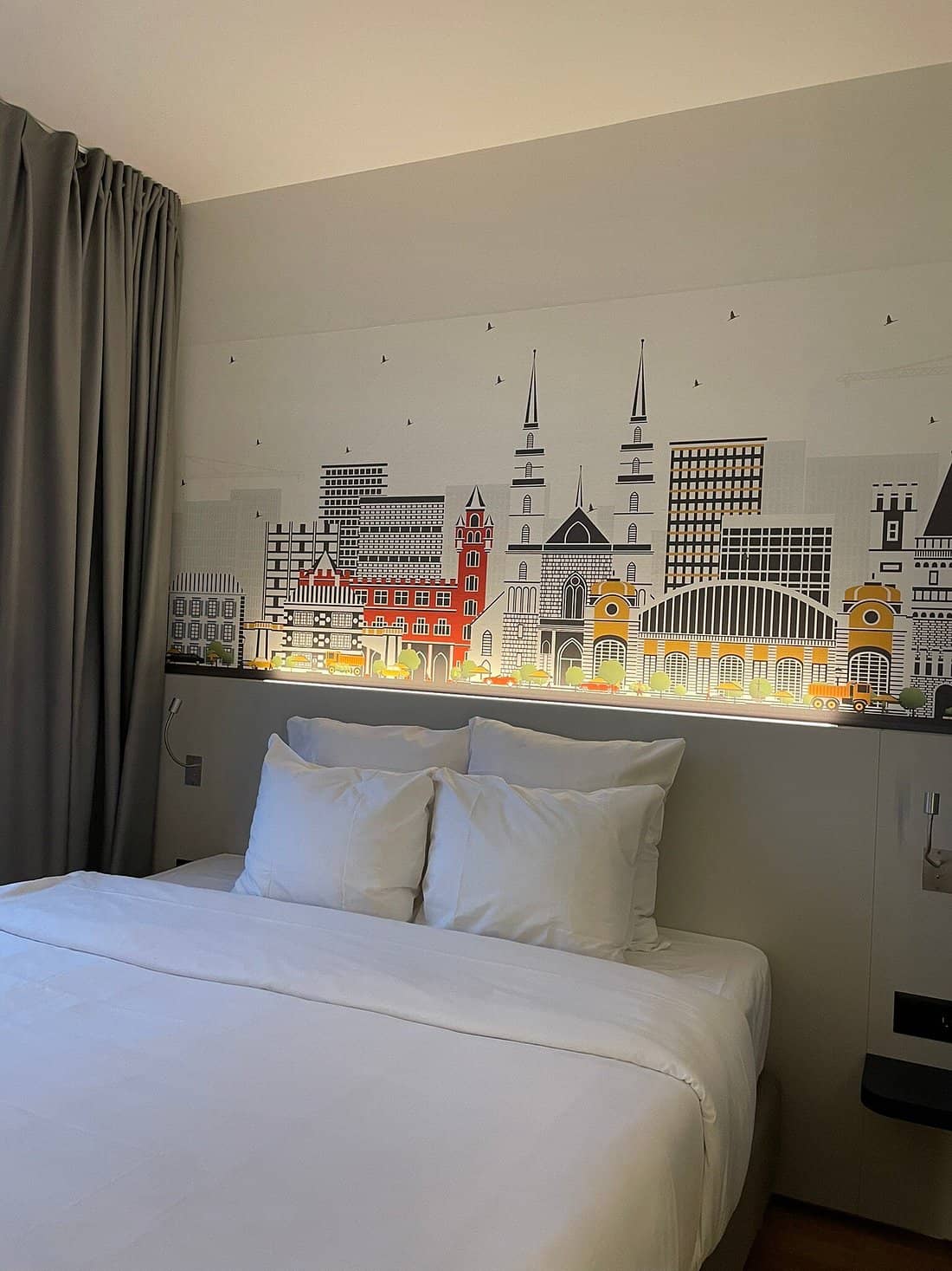 Modern room at BB Hotel Basel with a comfortable bed cityscape wall art and soft lighting