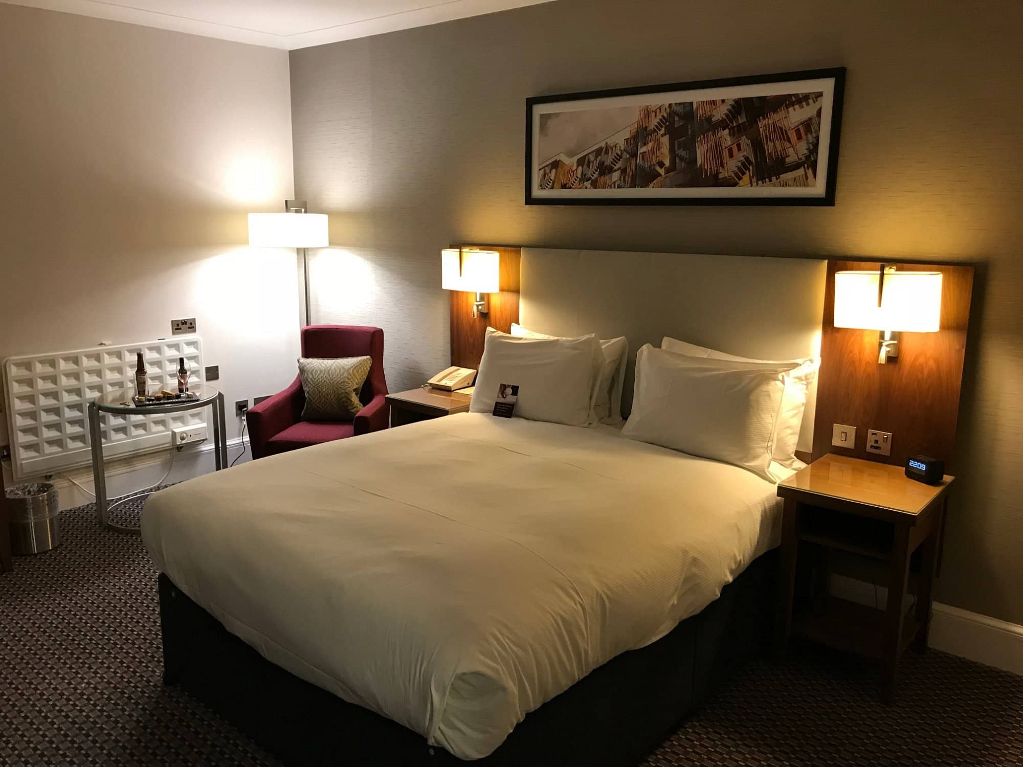  Cozy hotel room at DoubleTree by Hilton Edinburgh Airport with a large bed modern bedside lighting an armchair and minimal decor Comfortable and inviting setup