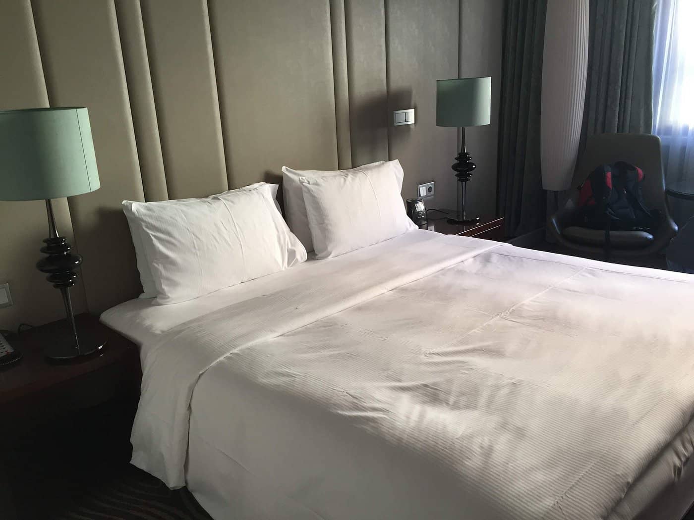 A stylish and comfortable room at Hilton Berlin featuring a plush bed and chic lighting