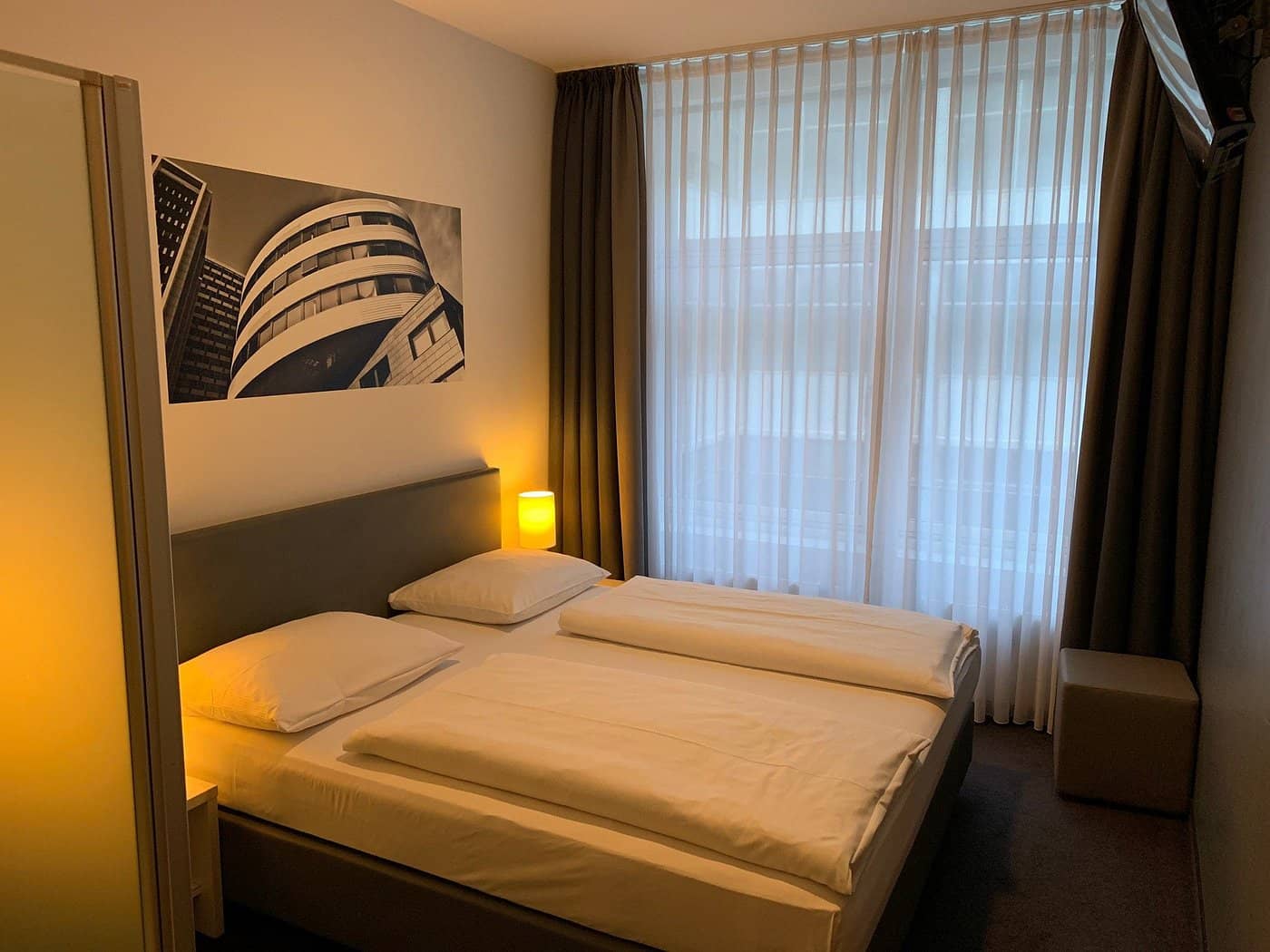 The Hotel Berlin Gendarmenmarkt room boasts modern decor and soft lighting for a relaxing stay