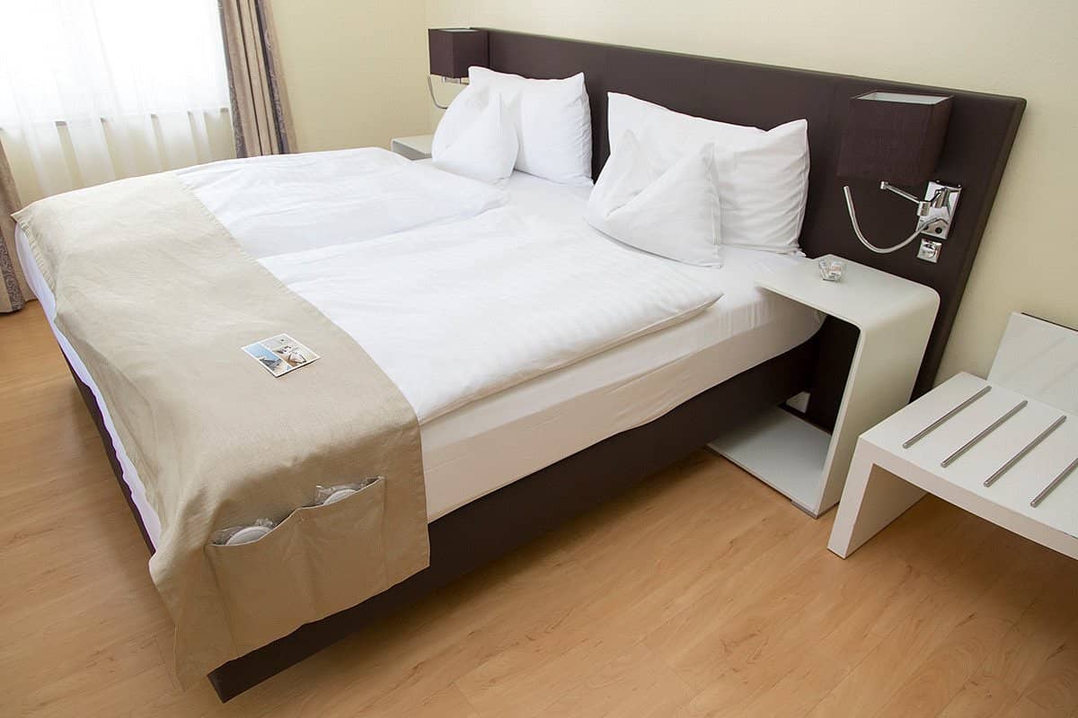 Comfortable room at Hotel Spalentor featuring a cozy bed modern headboard with built-in lighting and sleek minimalist bedside tables