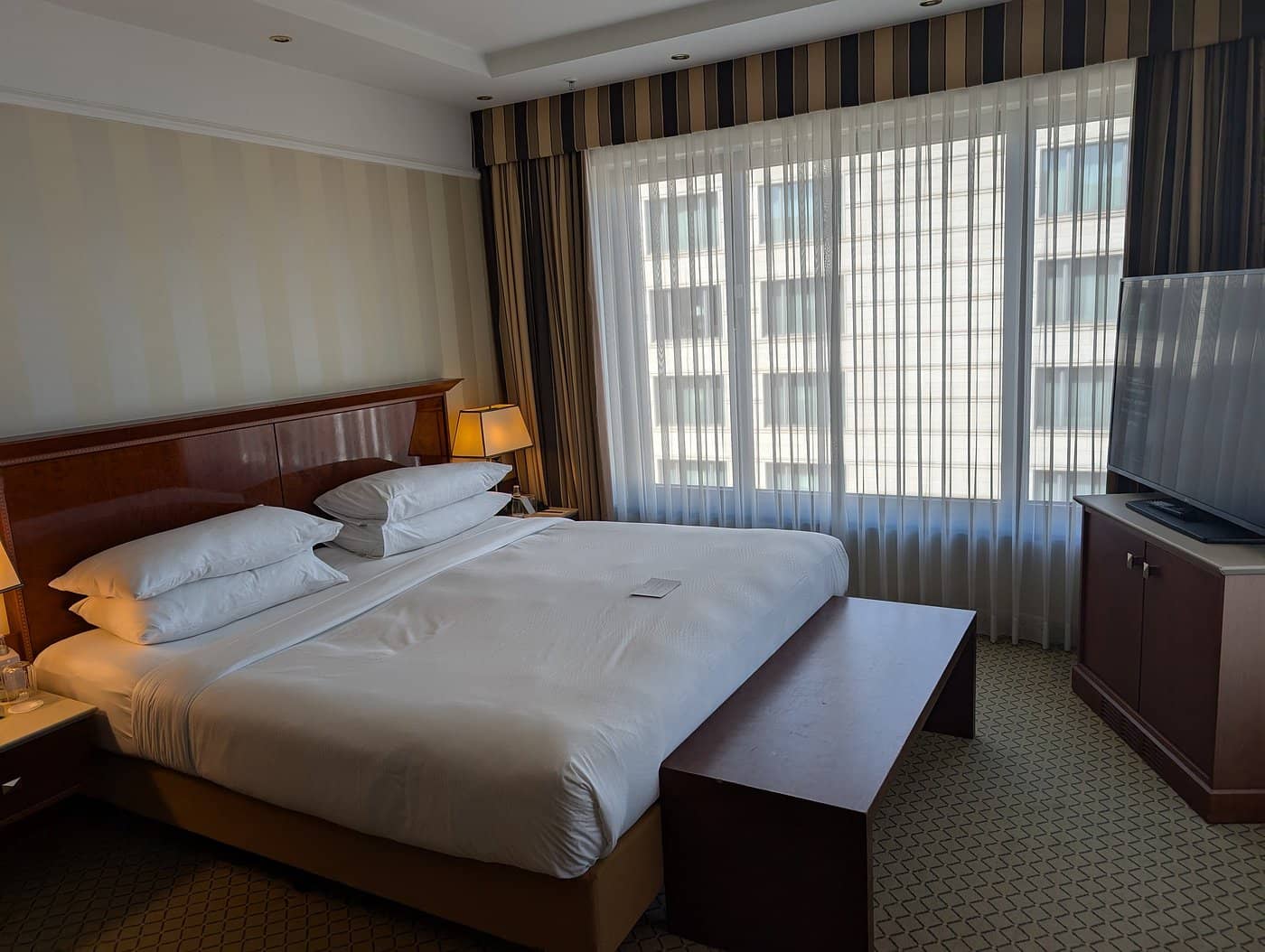 A spacious and elegant room at JW Marriott Hotel Berlin with a luxurious bed and ample natural light