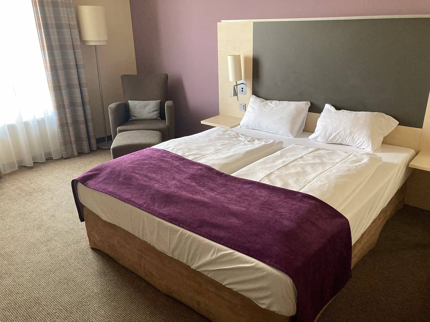 The Mercure Hotel Berlin City West room offers a cozy ambiance with plush bedding and a comfortable seating area for relaxation