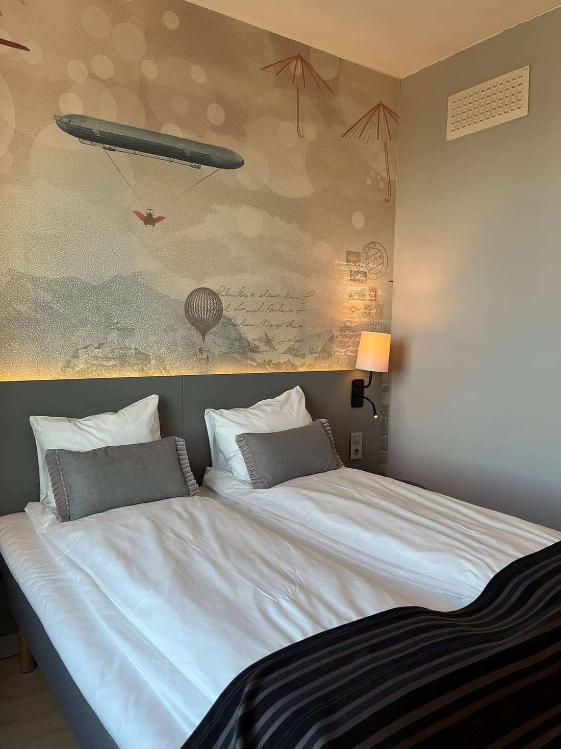 A modern room at Scandic Byporten with whimsical wall art crisp white linens and cozy decor for a comfortable stay in Oslo