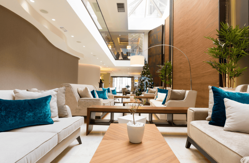 A luxurious seating area with plush sofas, teal cushions, and a bright, modern ambiance—perfect for experiencing the best hotels in Oslo.