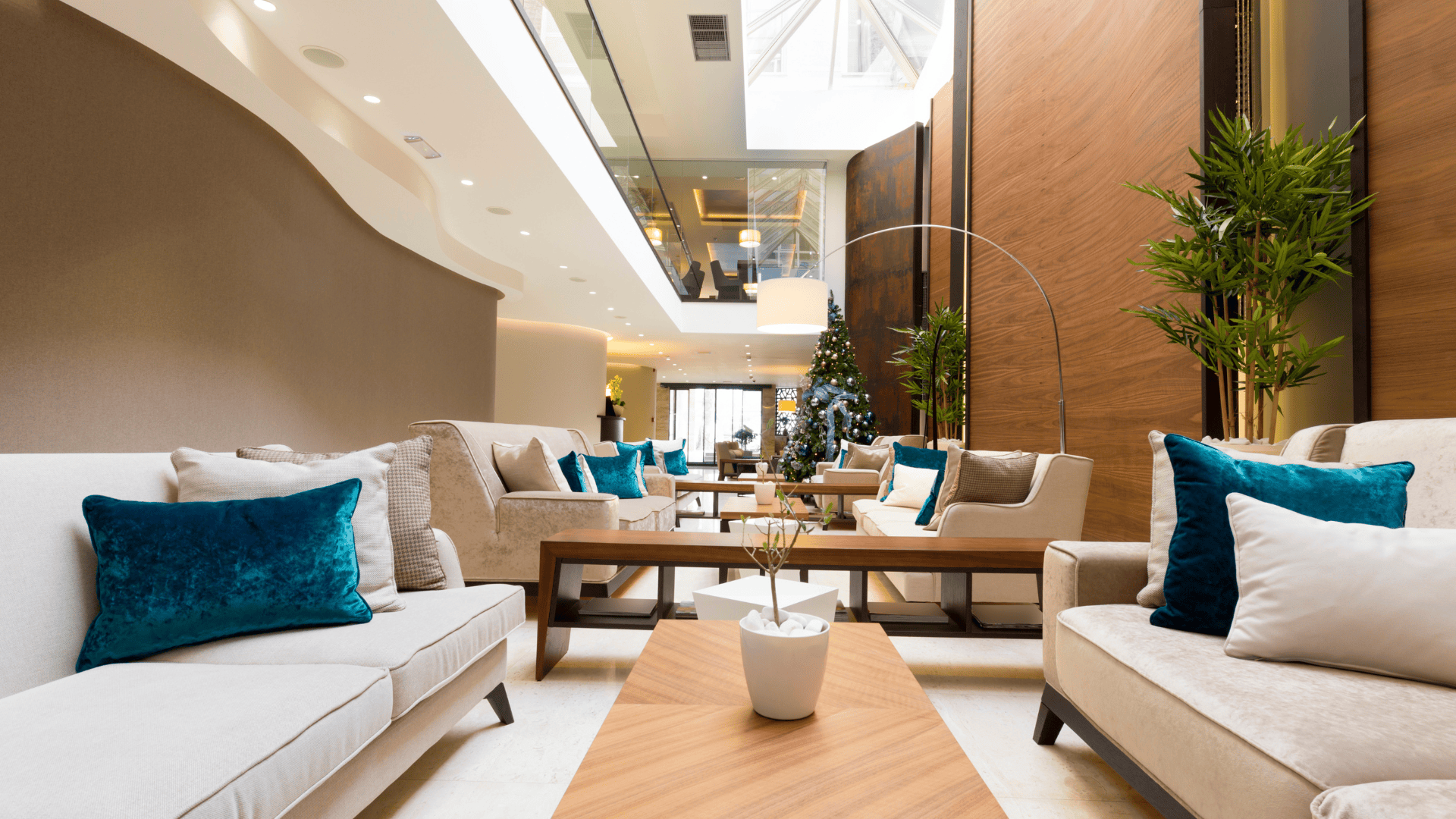 A luxurious seating area with plush sofas, teal cushions, and a bright, modern ambiance—perfect for experiencing the best hotels in Oslo.